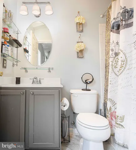 a bathroom with a toilet sink vanity and mirror
