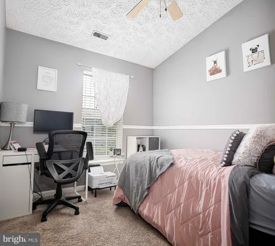 a bedroom with a bed and a computer on the desk