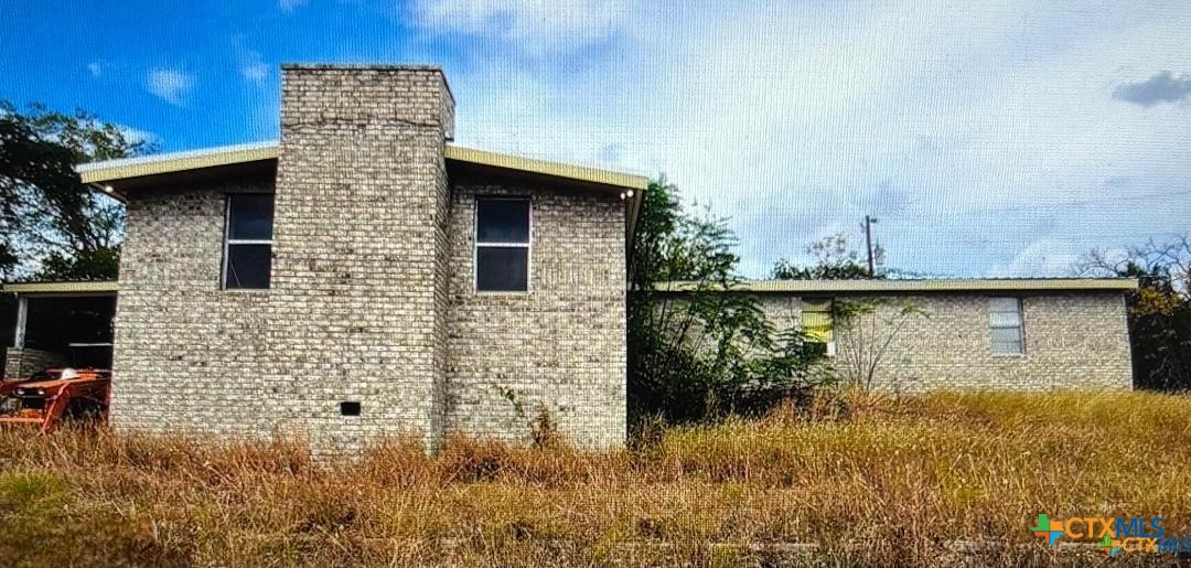 1653 County Road 4953 Kempner, TX 76539 - Photo 1 of 1 a brick house with a yard next to a lake