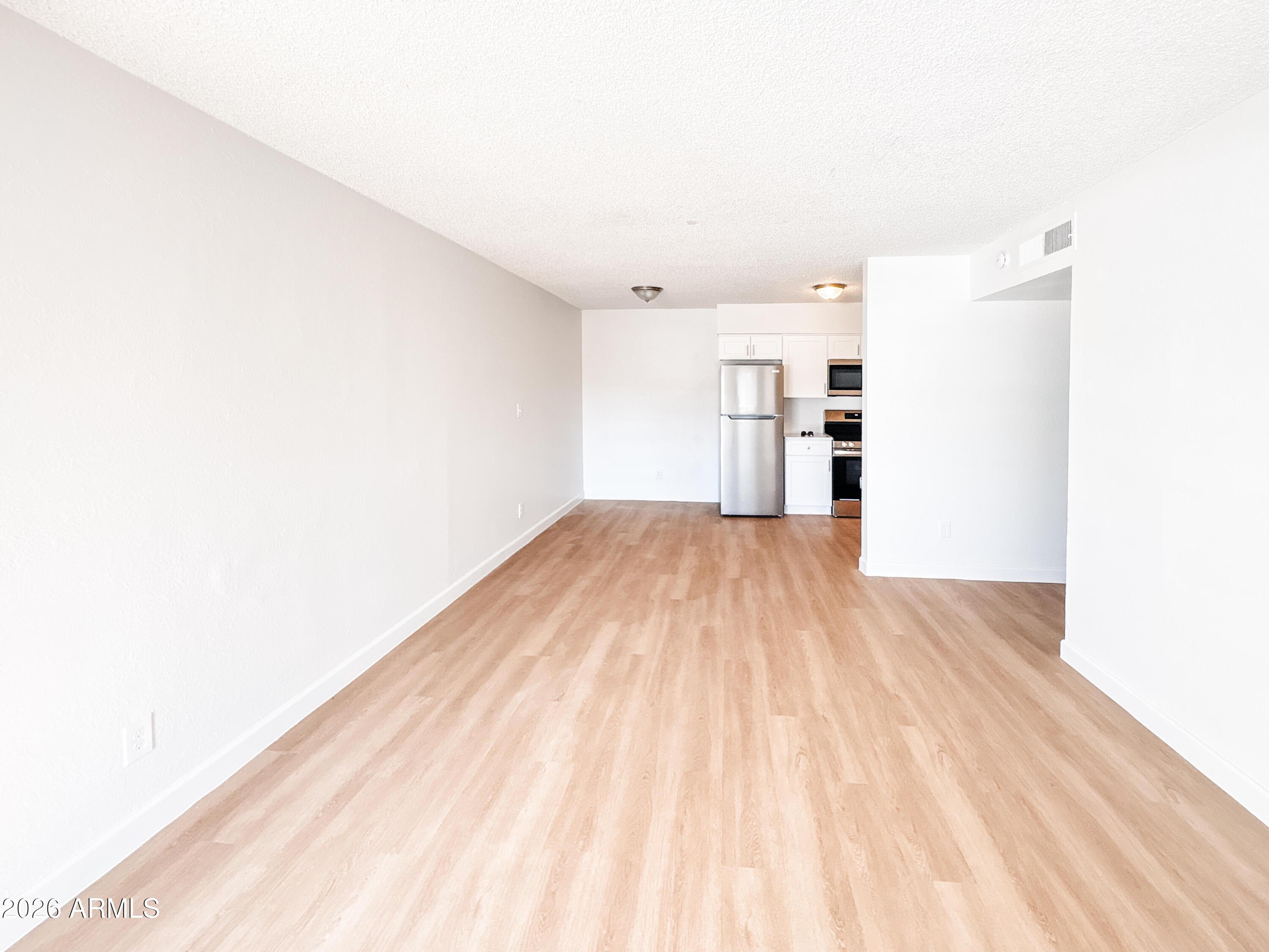 2615 East Greenway Road, Unit 21 Phoenix, AZ 85032 - Photo 14 of 19 a view of empty room with wooden floor