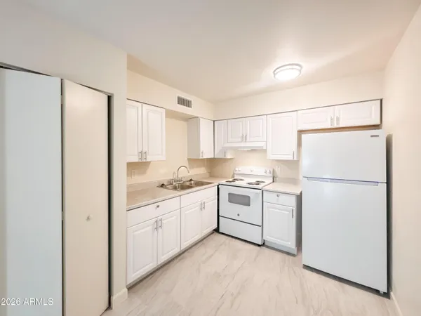 a kitchen with white cabinets and white appliances