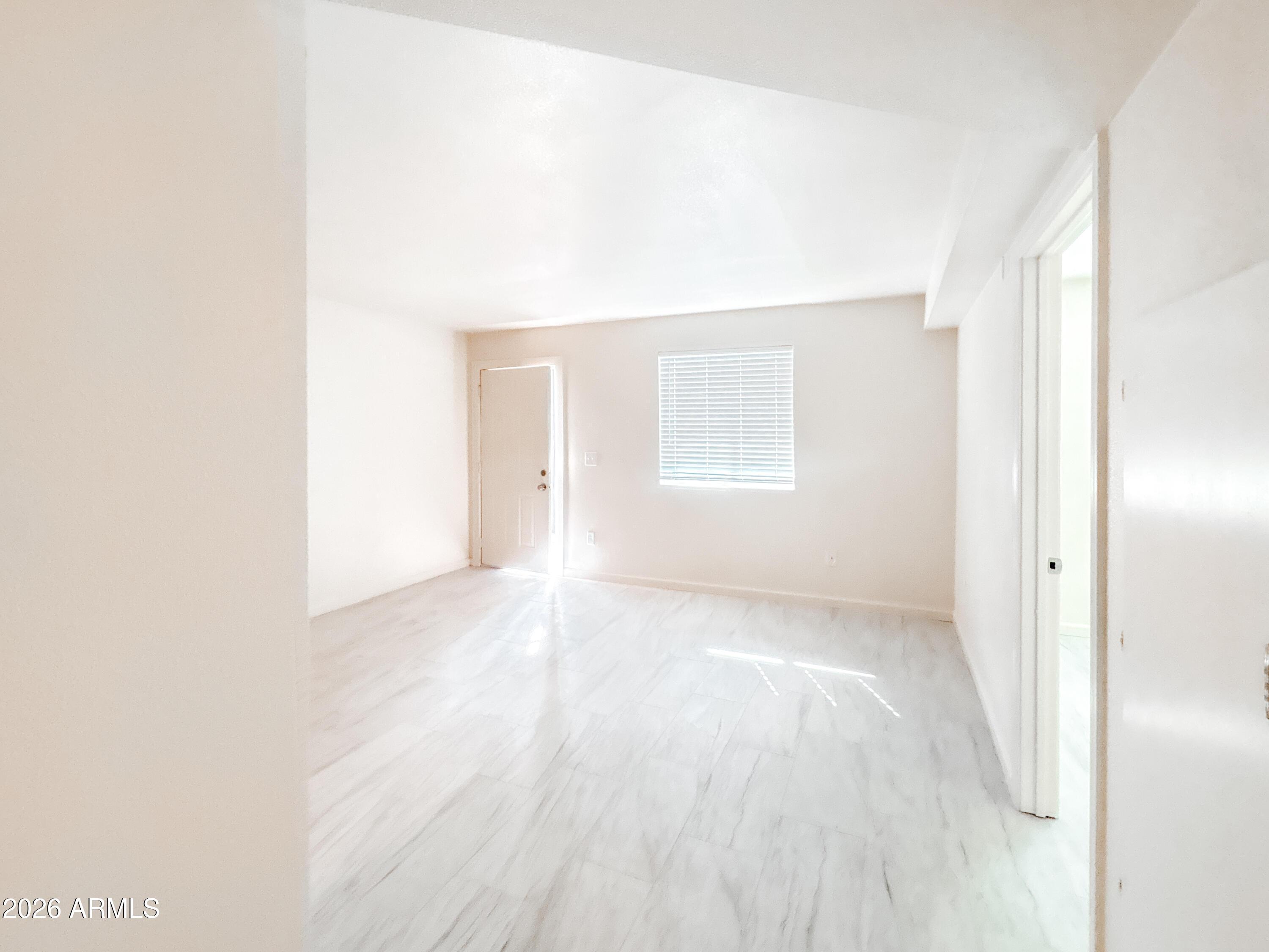 2615 East Greenway Road, Unit 21 Phoenix, AZ 85032 - Photo 18 of 19 a view of an empty room with wooden floor and a window