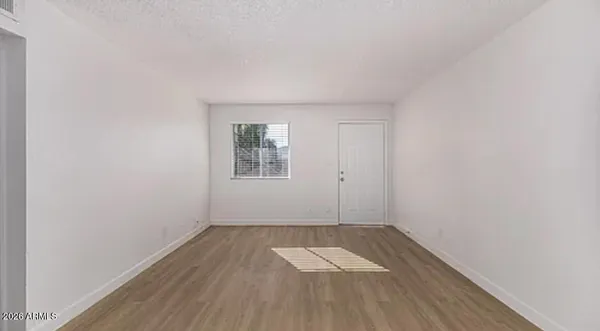an empty room with a hardwood and wooden floor