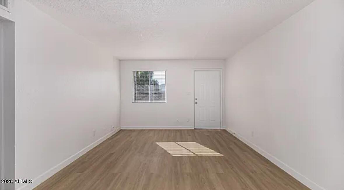 2615 East Greenway Road, Unit 21 Phoenix, AZ 85032 - Photo 5 of 19 an empty room with a hardwood and wooden floor