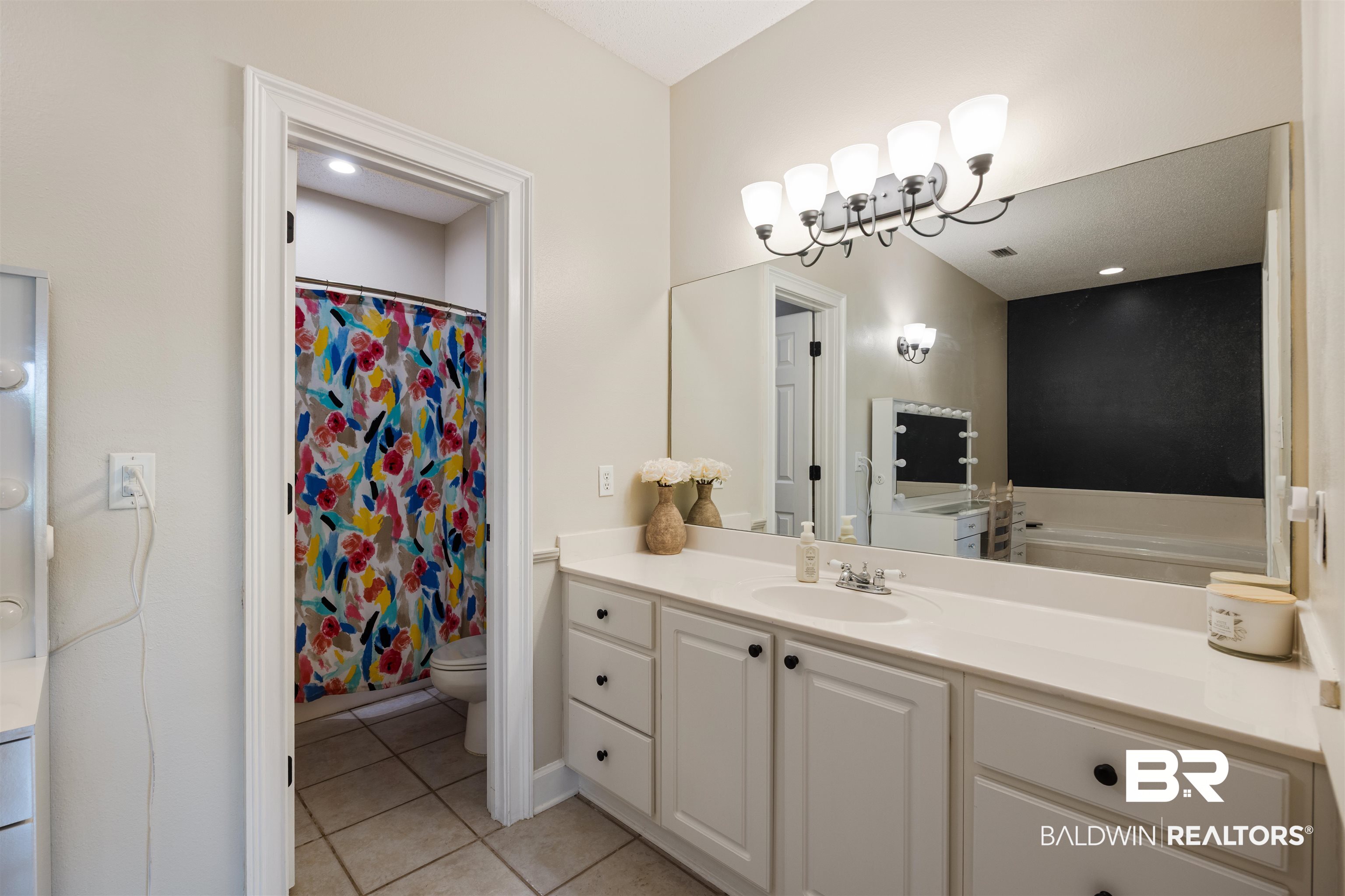 9855 Stucki Road Elberta, AL 36530 - Photo 34 of 54 Bathroom featuring vanity, a shower with shower curtain, light tile patterned floors, a garden tub, and recessed lighting