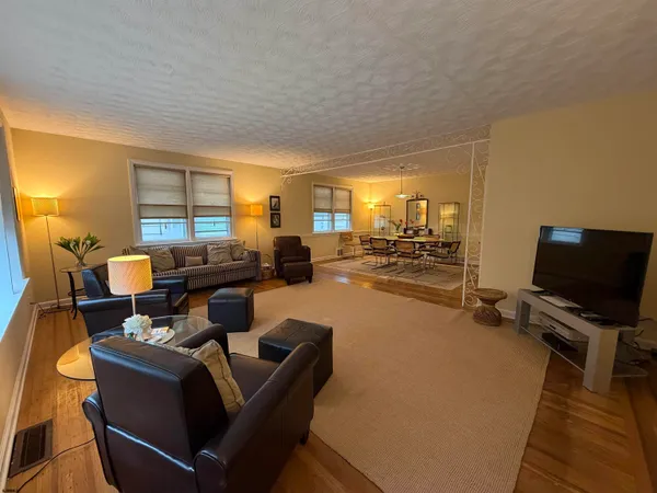 a living room with furniture and a wooden floor