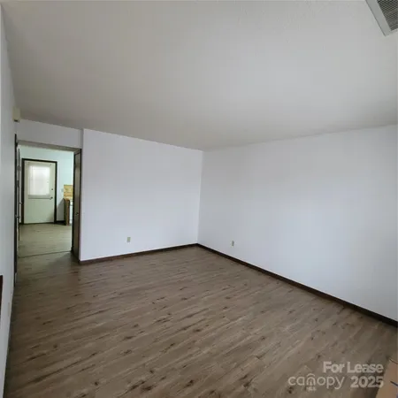 a view of a room with wooden floor