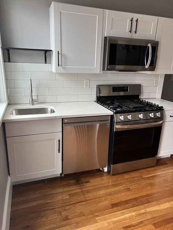 840 Massachusetts Avenue, Unit 8 Arlington, MA 02476 - Photo 1 of 8 a kitchen with a stove and a microwave