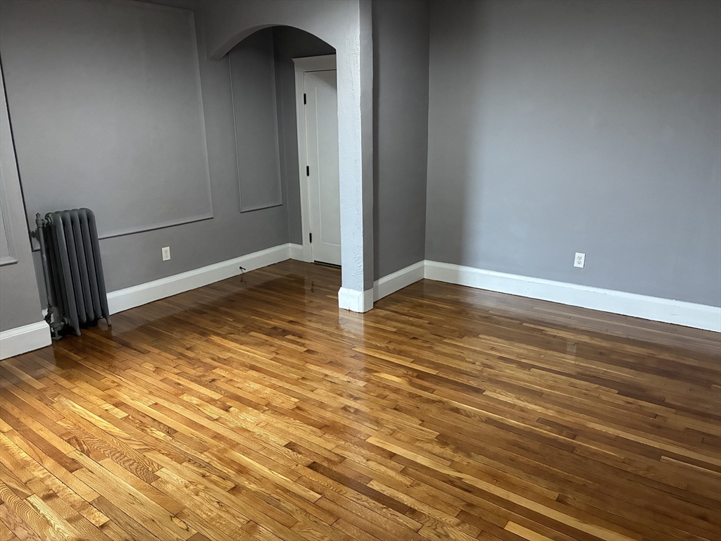 840 Massachusetts Avenue, Unit 8 Arlington, MA 02476 - Photo 6 of 8 a view of an empty room with wooden floor