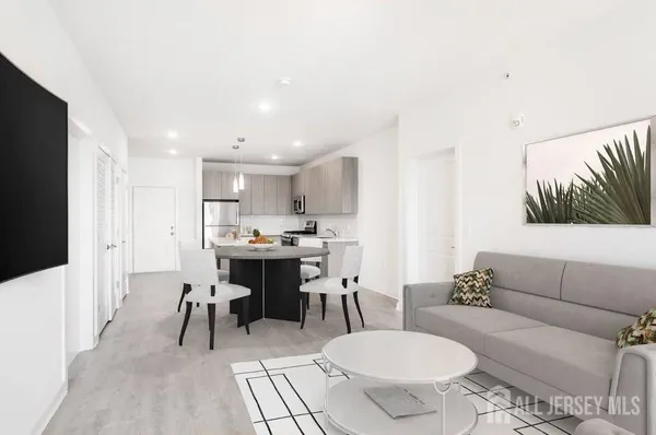 a living room with furniture and a dining table with kitchen view