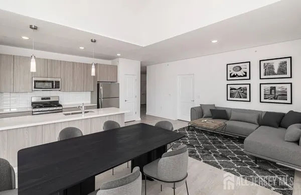 a kitchen with a dining table chairs and a refrigerator