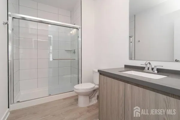 a bathroom with a granite countertop sink a toilet and a mirror