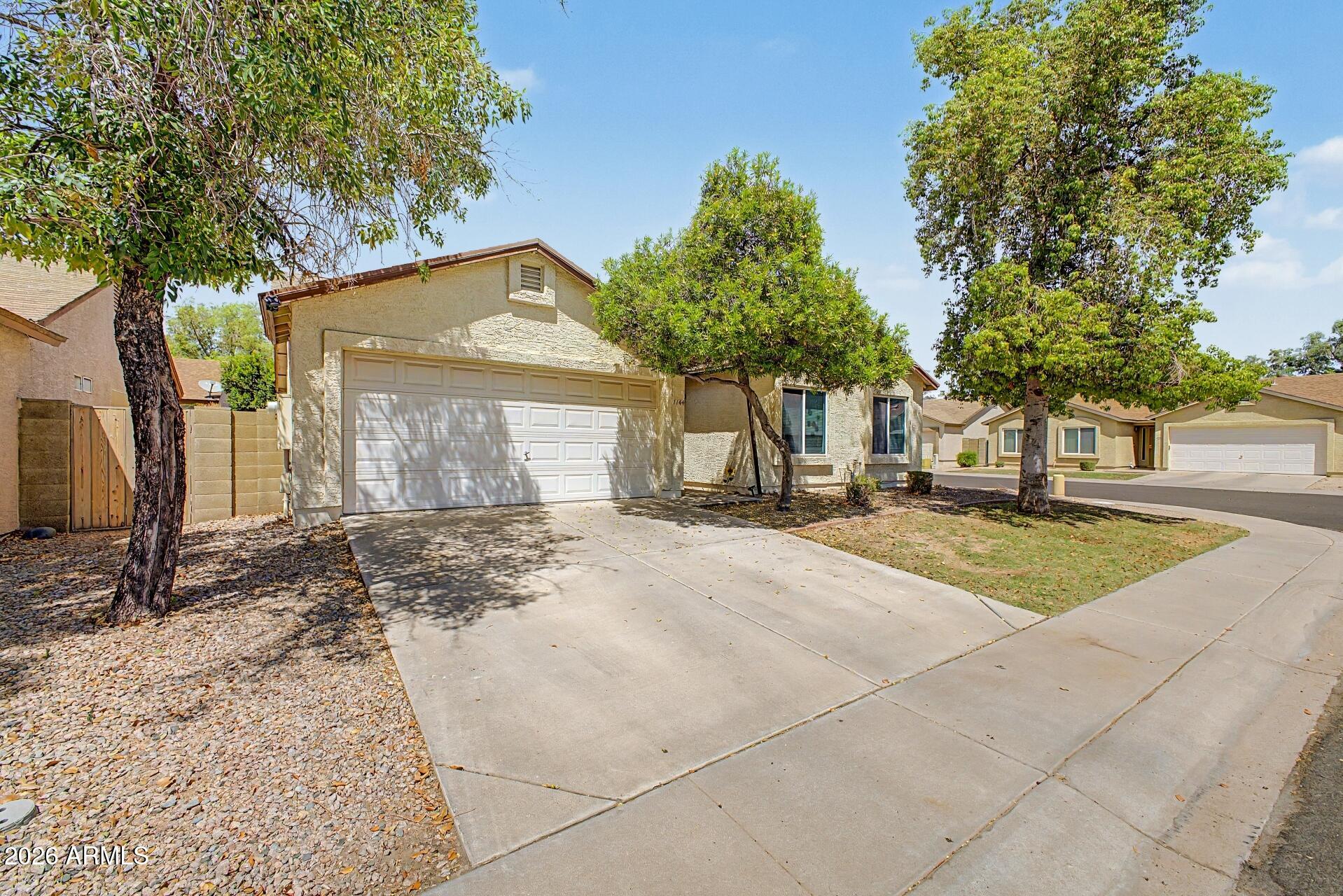 a view of a house with a yard and large tree