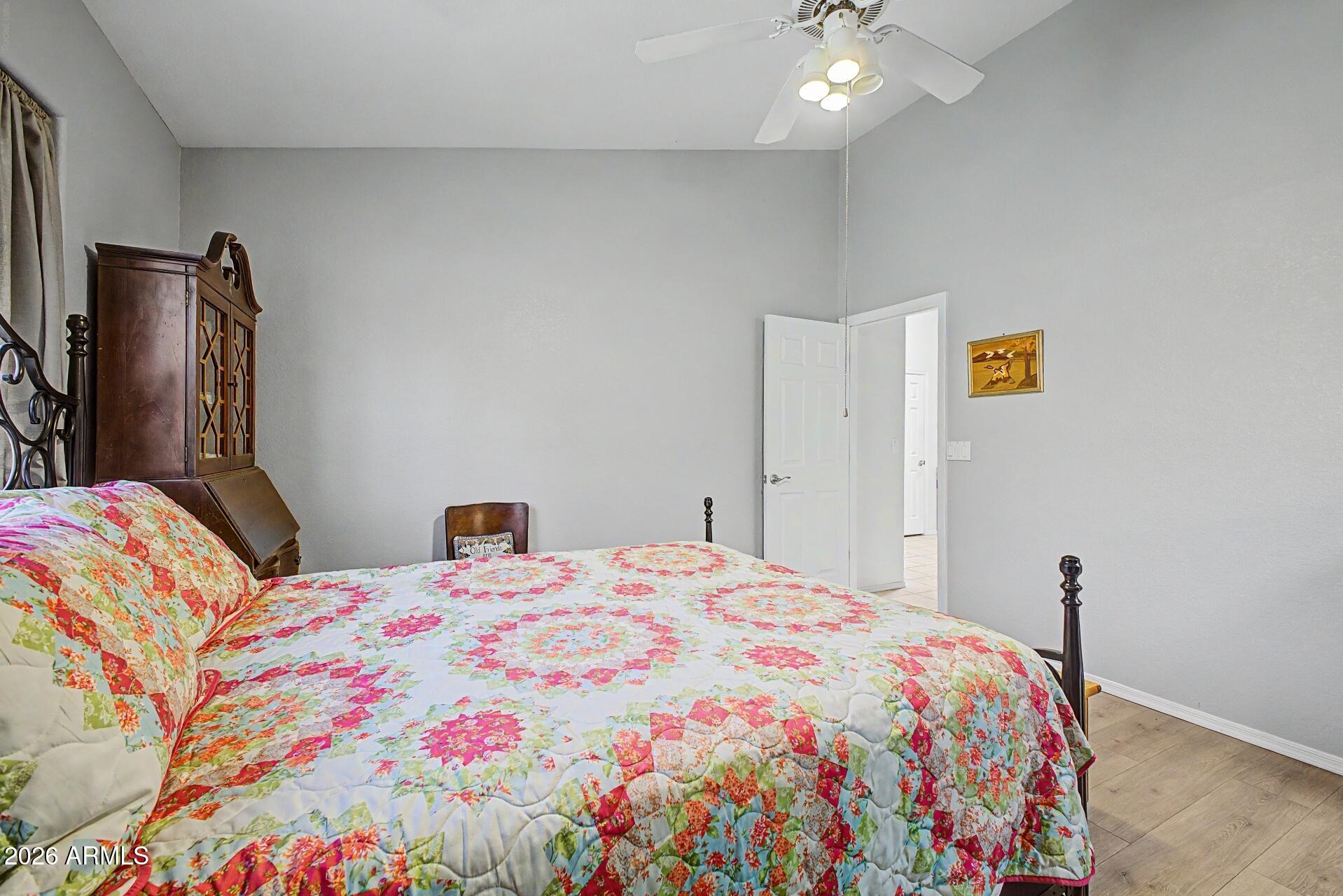 6335 East Brown Road, Unit 1144 Mesa, AZ 85205 - Photo 13 of 28 a bedroom with a bed and a chandelier