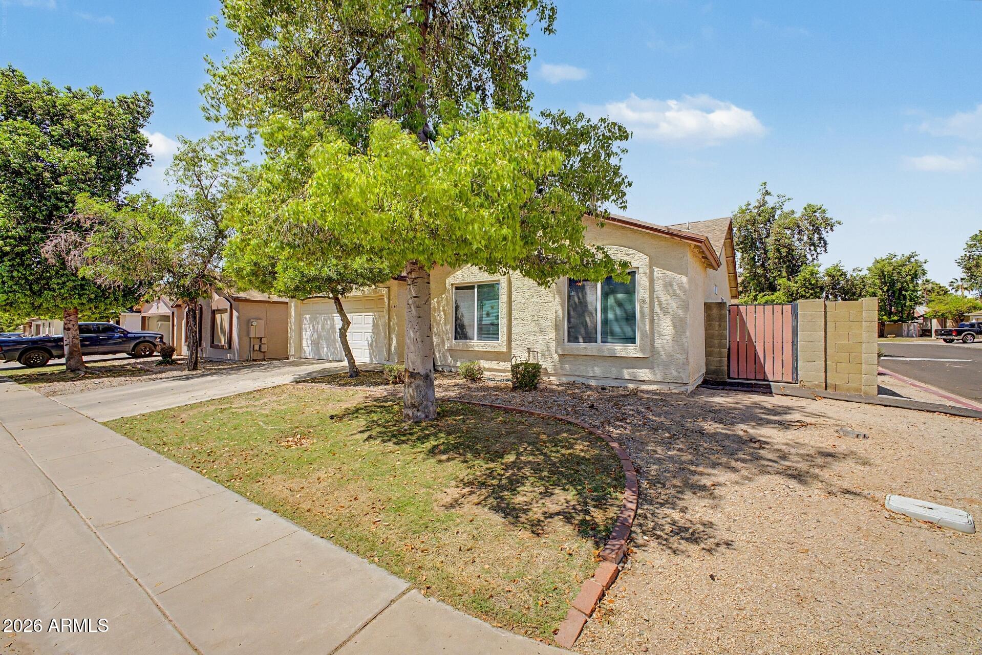 6335 East Brown Road, Unit 1144 Mesa, AZ 85205 - Photo 2 of 28 a view of a white house with a swimming pool and a yard