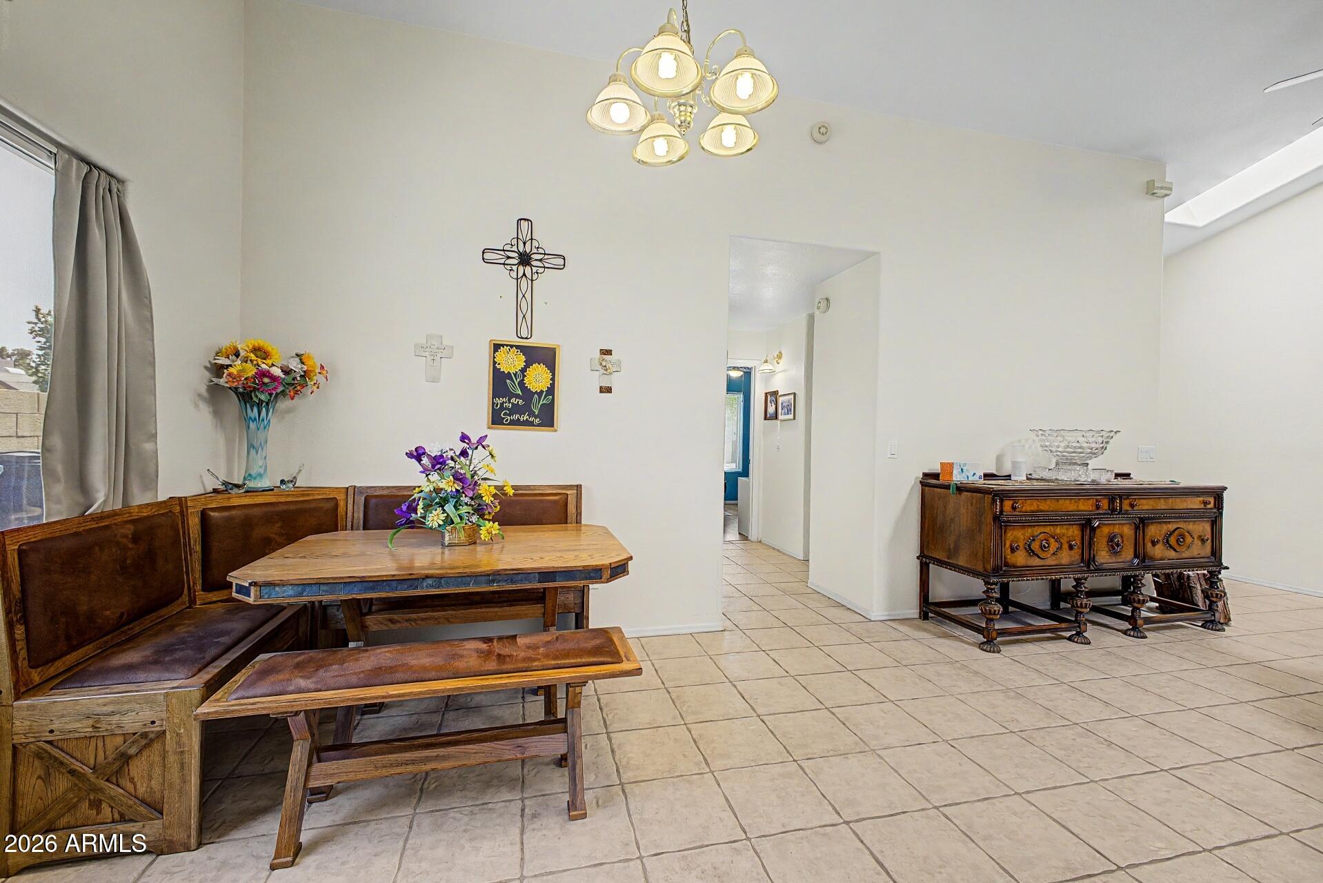 6335 East Brown Road, Unit 1144 Mesa, AZ 85205 - Photo 10 of 28 a dining room with furniture and a chandelier