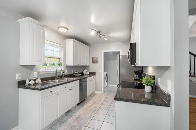 a kitchen with stainless steel appliances granite countertop a sink a stove a refrigerator a counter top space and cabinets