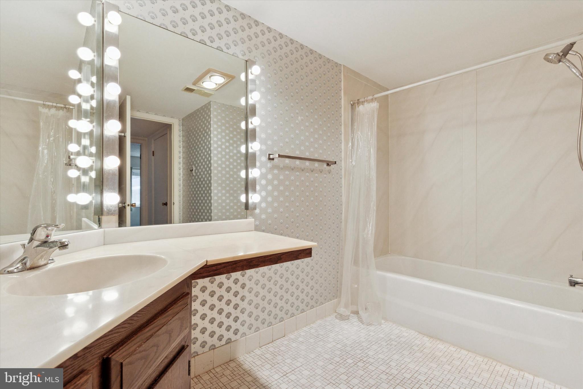 1219 West Wynnewood Road, Unit 400 Wynnewood, PA 19096 - Photo 14 of 15 a bathroom with a tub sink and mirror