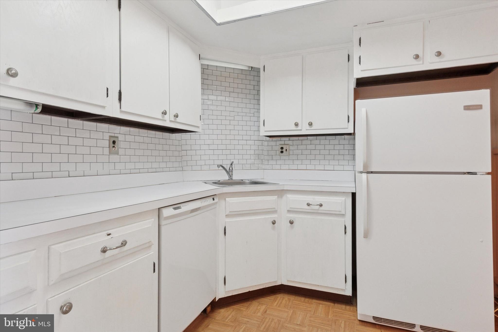 1219 West Wynnewood Road, Unit 400 Wynnewood, PA 19096 - Photo 10 of 15 a kitchen with white cabinets and white appliances