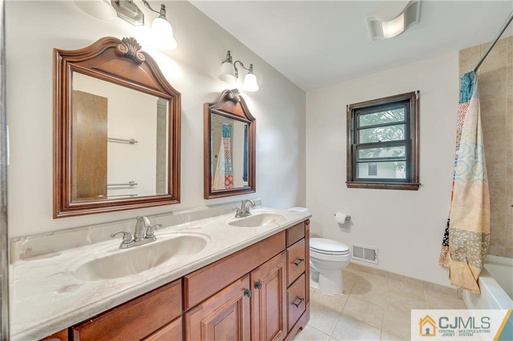 65 Dellwood Road Edison, NJ 08820 - Photo 12 of 24 a bathroom with a granite countertop sink a toilet and a mirror