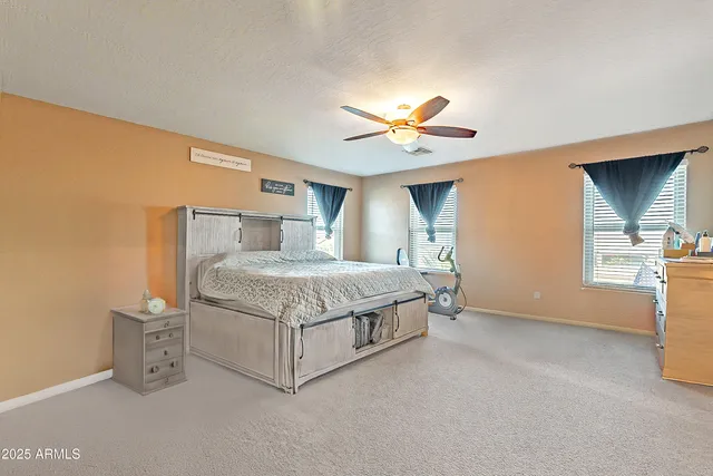 a bedroom with a large bed and a chandelier