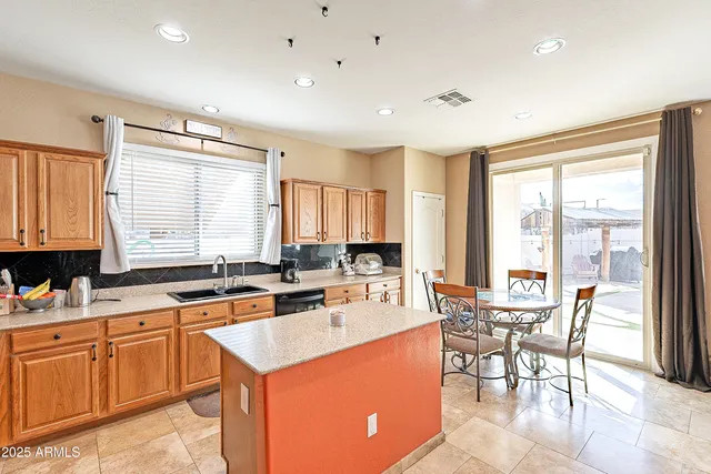 a kitchen with a stove a sink a dining table and chairs with wooden floor