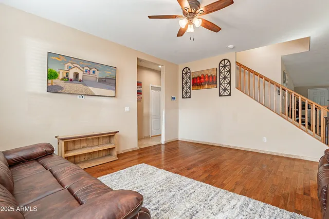 a living room with furniture and a ceiling fan