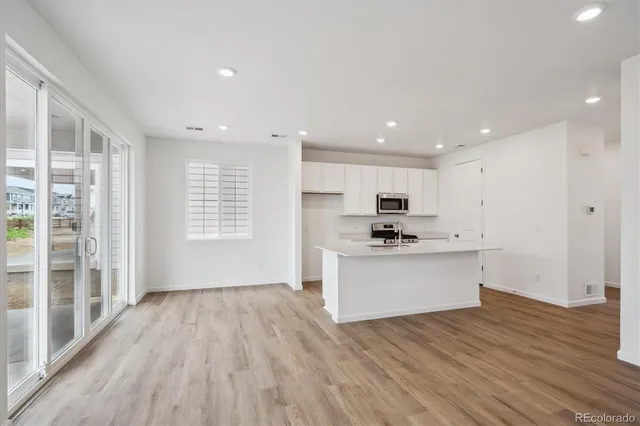 a kitchen with a white stove top oven and white cabinets
