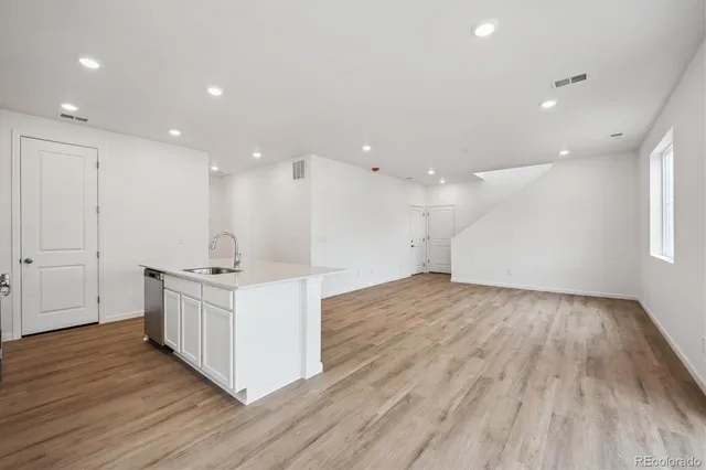 a kitchen with a sink and wooden floor