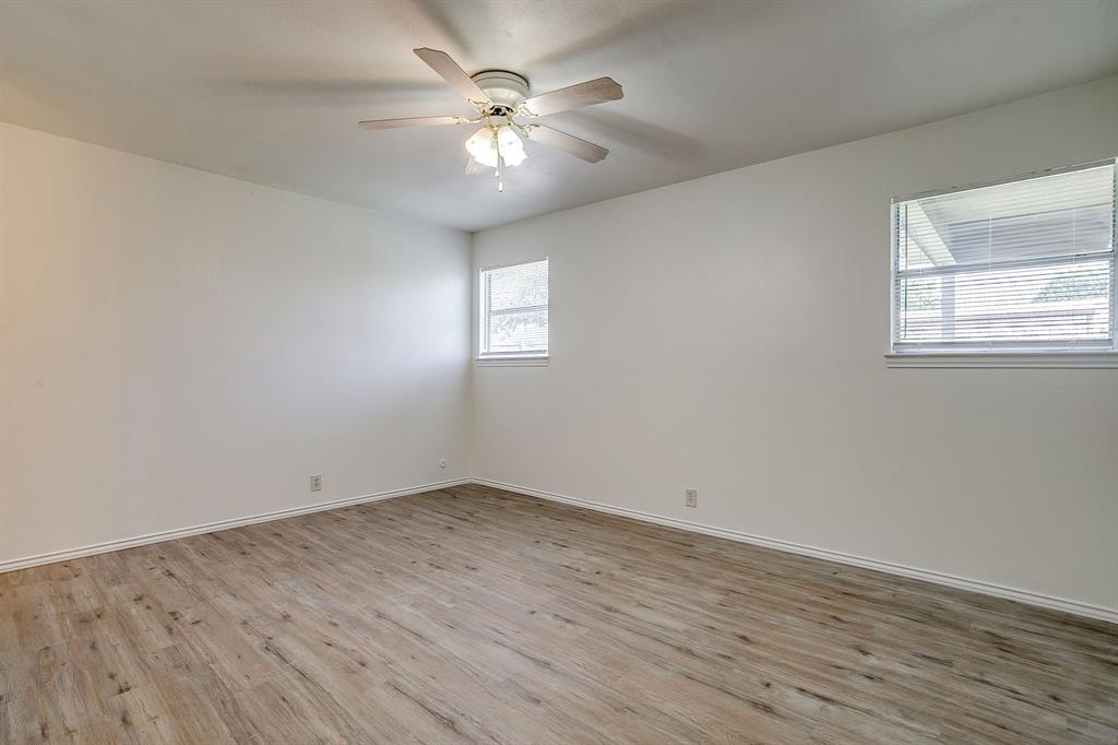 1203 North Nolan River Road, Unit A Cleburne, TX 76033 - Photo 12 of 20 an empty room with wooden floor and windows