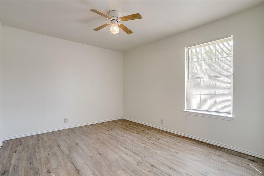 1203 North Nolan River Road, Unit A Cleburne, TX 76033 - Photo 15 of 20 an empty room with wooden floor fan and windows