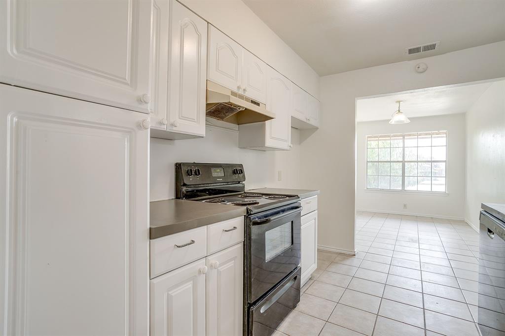 1203 North Nolan River Road, Unit A Cleburne, TX 76033 - Photo 8 of 20 a kitchen with stainless steel appliances granite countertop a stove a sink and a refrigerator