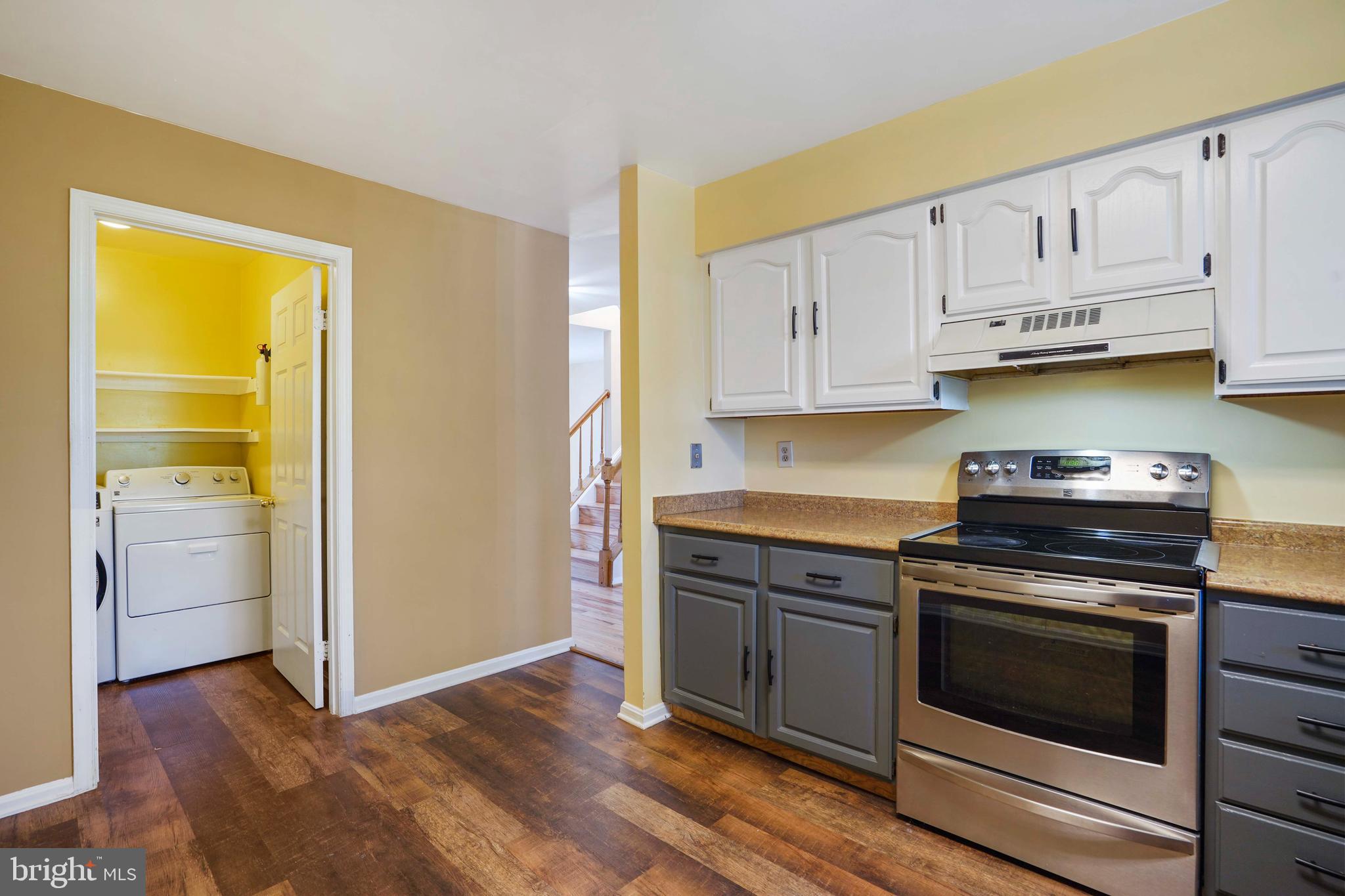 11322 Baritone Court Silver Spring, MD 20901 - Photo 3 of 29 a kitchen with granite countertop wooden floors and stainless steel appliances