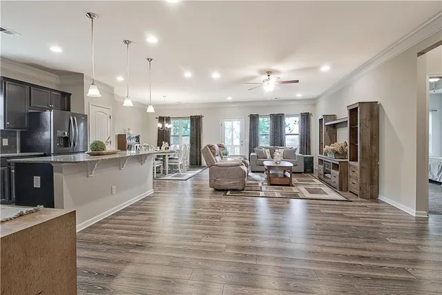 a large room with stainless steel appliances lots of counter space and wooden floor