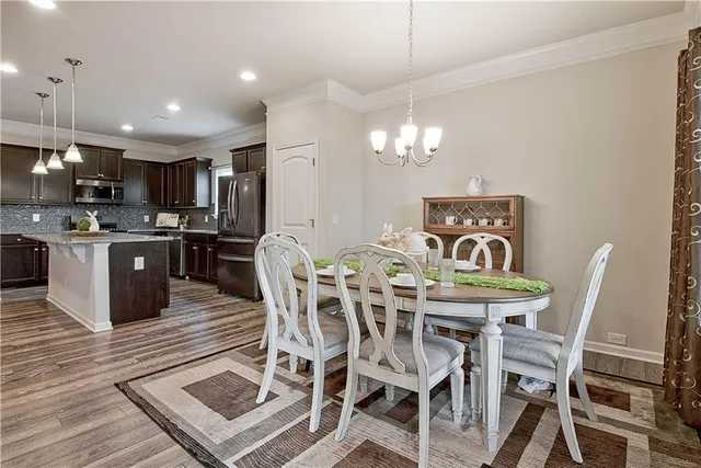 a view of a dining room with furniture a chandelier and wooden floor