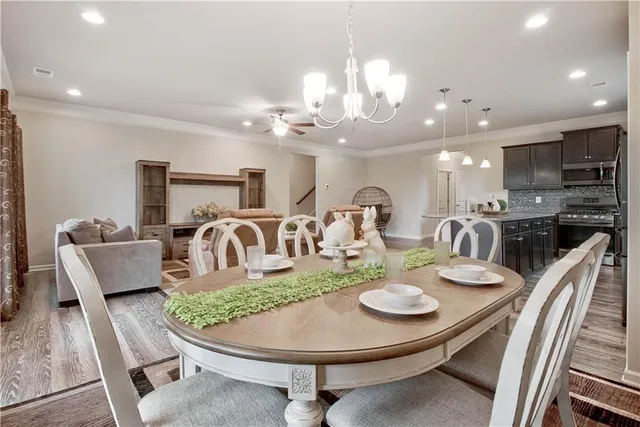 a dining room with furniture a chandelier and kitchen view