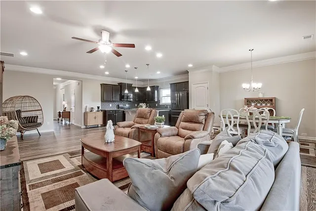 a living room with furniture kitchen view and a chandelier