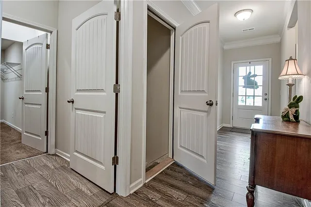 a view of a hallway with wooden chairs