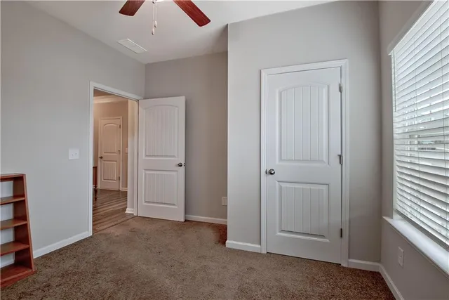 an empty room with closet and a window