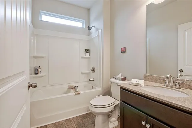 a bathroom with a bathtub shower sink mirror vanity and toilet