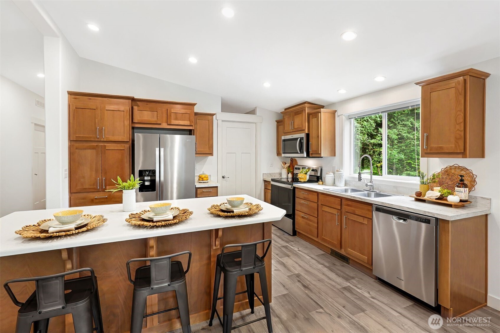 2815 Middle Shore Road Snohomish, WA 98290 - Photo 5 of 26 a kitchen with stainless steel appliances kitchen island granite countertop a stove a sink a refrigerator dining table and chairs with wooden floor