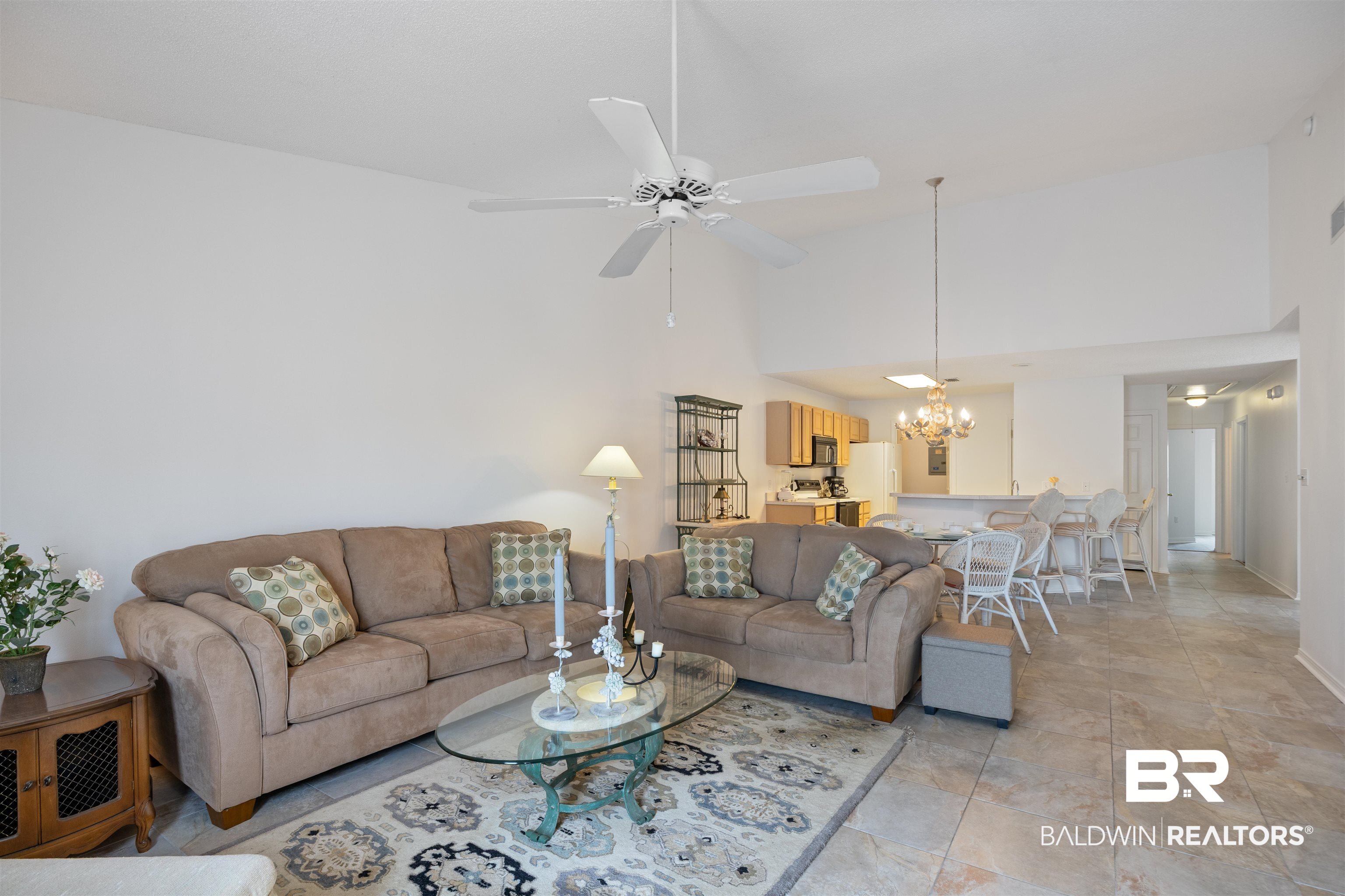3200 Loop Road, Unit 96 Orange Beach, AL 36561 - Photo 23 of 49 Vaulted ceiling living area featuring ceiling fan light fixture, tile flooring, and an open layout to the kitchen with breakfast bar
