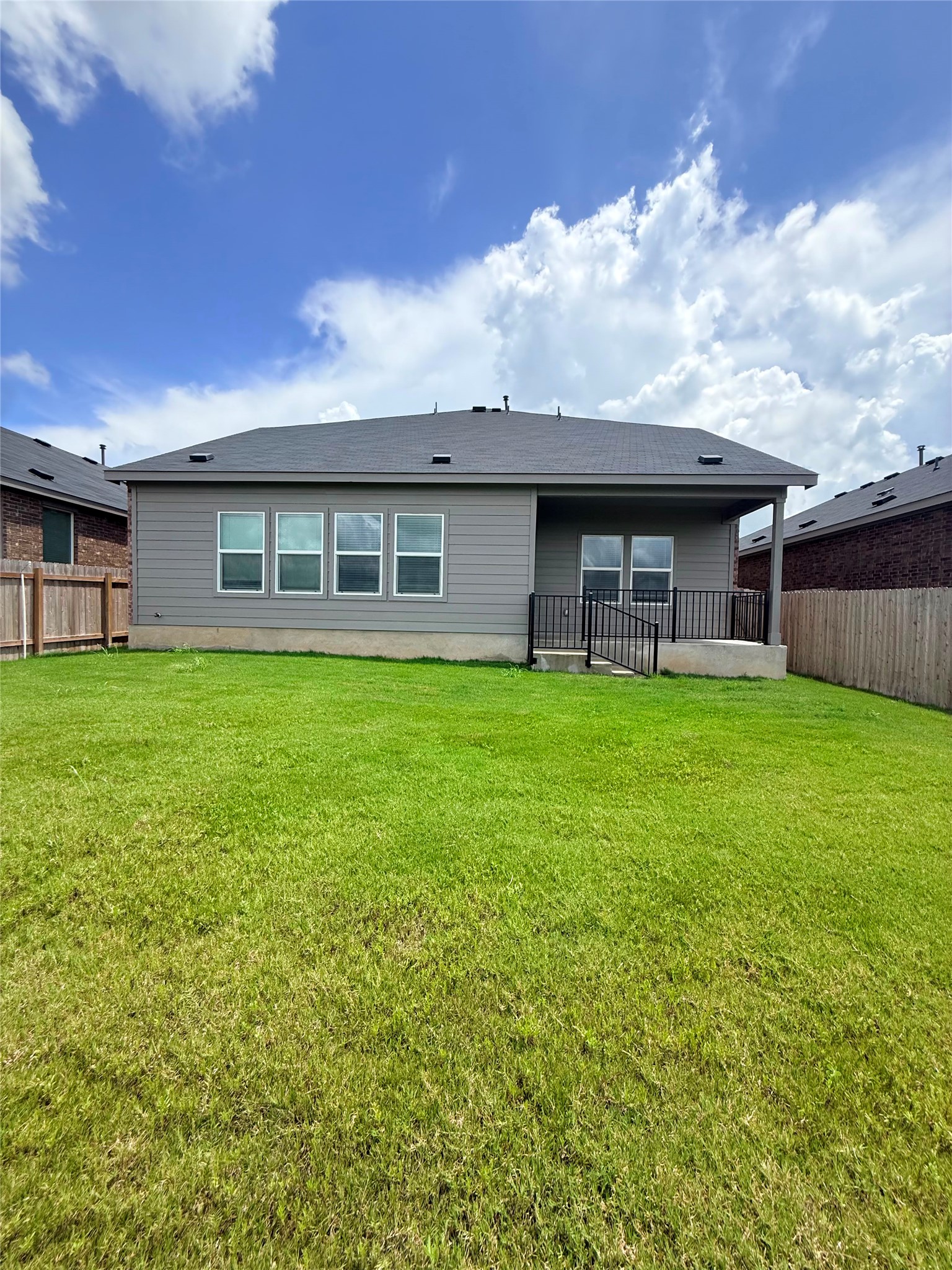 192 Rodney Boat Road Kyle, TX 78640 - Photo 2 of 40 A spacious backyard with vibrant green grass offers ample outdoor living space.