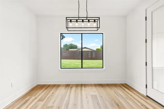 a view of a room with wooden floor a ceiling fan and window