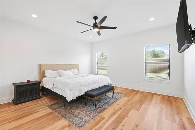 a spacious bedroom with a bed and a flat screen tv