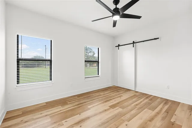 a view of a bedroom with a window and a ceiling fan