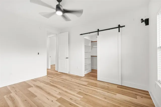 a view of a room with wooden floor and ceiling fan