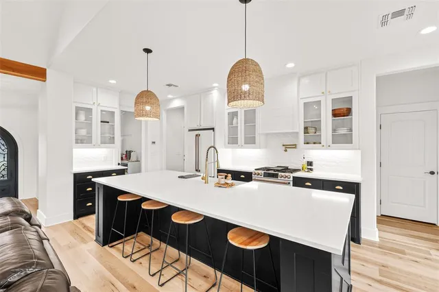 a kitchen that has a stove a table and chairs in it