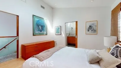a bedroom with a bed and a lamp on dresser
