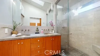 a bathroom with a granite countertop sink a mirror and shower